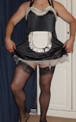 Male submissive in French maid outfit with stockings, illustrating humiliation tasks a Domme can set her sub