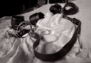 BDSM Aftercare Guide: Emotional Drop, Recovery and Staying Connected After Play Leather cuffs and collar resting on soft bedding after a BDSM scene