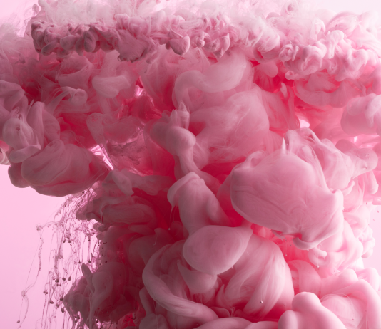 Pink ink swirling in water symbolising the experience of orgasm and sexual pleasure