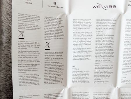 Close-up of the We-Vibe Wand 2 compliance and safety information leaflet showing disposal notes and environmental compliance information