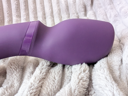 Close-up of the We-Vibe Wand 2 stimulation head showing the curved oblong shape and pale purple accent ring at the neck