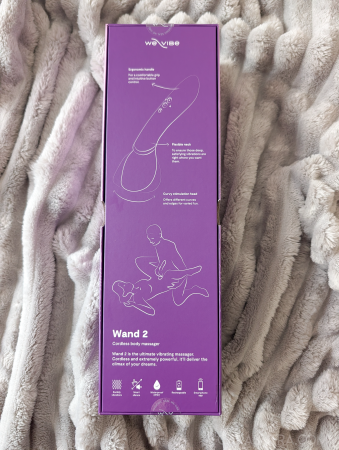 Back of the We-Vibe Wand 2 packaging showing the Wand 2 cordless body massager description, ergonomic handle and flexible neck feature diagrams