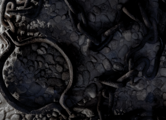 Rusted iron shackle and tangled chains on cold stone floor, cool-toned close-up
