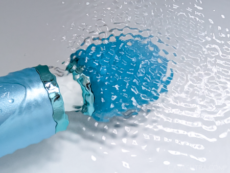 Le Wand Dive head fully submerged in bathwater, water swirling and bubbling around the silicone head to demonstrate underwater use