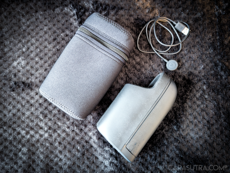 Arcwave Ion 2 black zip storage case laid flat beside the magnetic charging cable on a black blanket