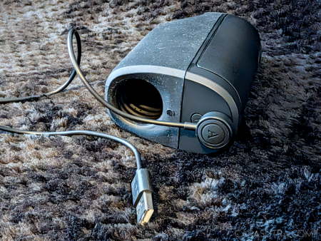 Arcwave Ion 2 lying on its side with the magnetic charging lead attached to the base
