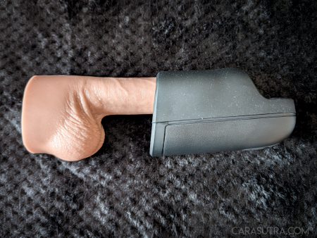 Arcwave Ion 2 black silicone stroker shown with a realistic dildo inserted fully into the sleeve, laid on a black blanket to demonstrate the toy’s length and fit around the shaft