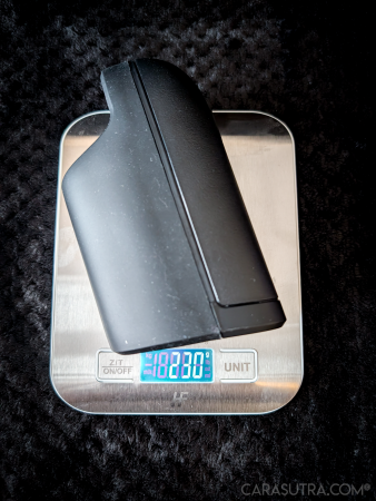 Arcwave Ion 2 stroker placed on a digital kitchen scale to show its weight, on a white surface