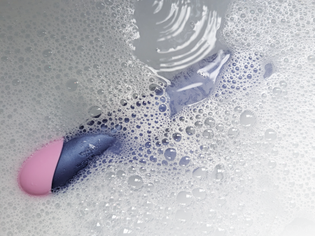 The waterproof ROMP Pulse Rabbit partly submerged in soapy water for cleaning