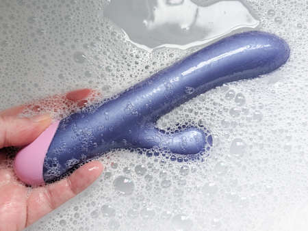 The ROMP Pulse Rabbit Vibrator held in a sink of soapy water, demonstrating it’s waterproof