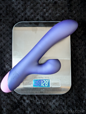 The ROMP Pulse Rabbit Vibrator sitting on a kitchen scale to show its weight is 128g